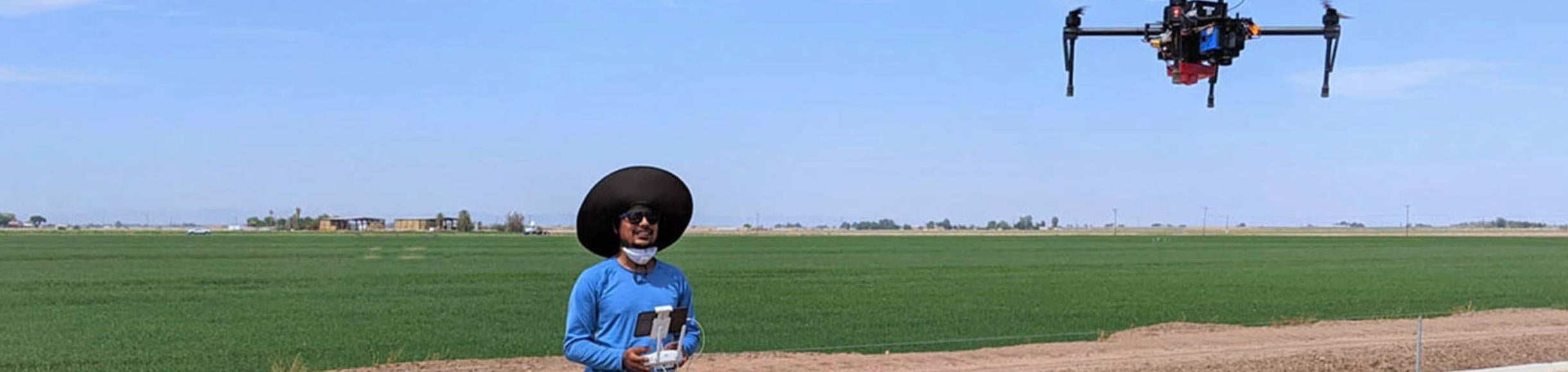 Amir Haghverdi Lab student flying a drone in a field